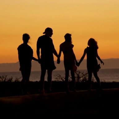 Menschen halten sich an den Händen im Sonnenuntergang – Gemeinschaft in unserer Facebook-Gruppe für Auswanderer-Familien