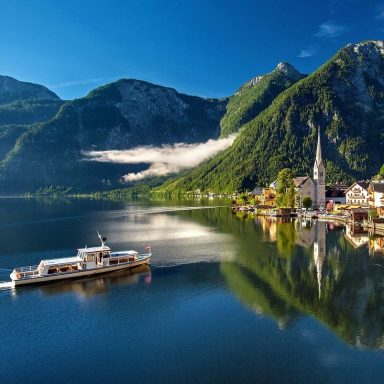 Berglandschaft in Österreich mit grünen Wiesen und klarer Luft – ideal für Familien, die Natur und hohe Lebensqualität suchen.