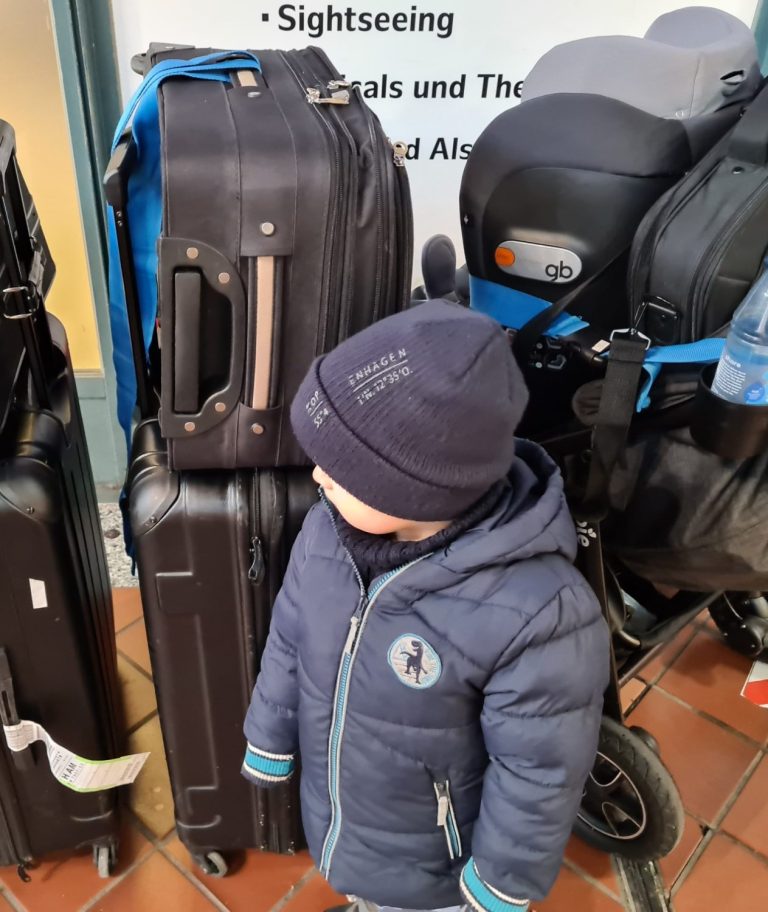 Familienauswanderung: Kind mit gepackten Koffern auf dem Weg ins neue Leben