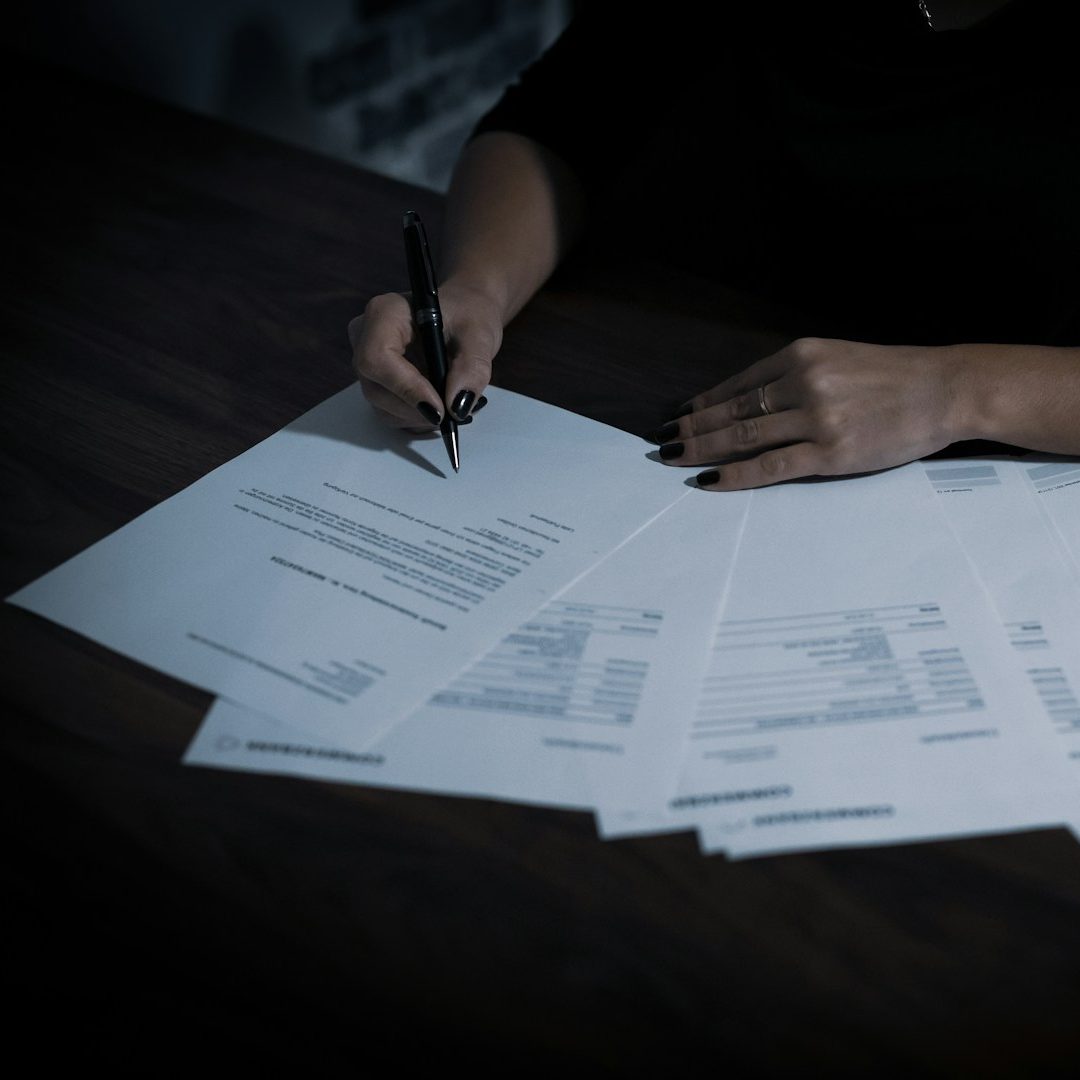 Hand schreibt auf Zettel – To-do-Liste für Familien vor der Auswanderung